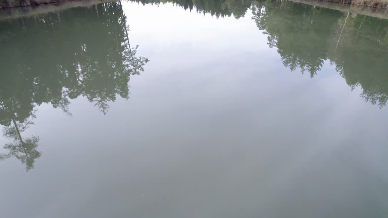 호수 위를 날아다니며 보트를 보관하기 위해 사용 된 나무 창고를 서서히 드러내는 항공 영상