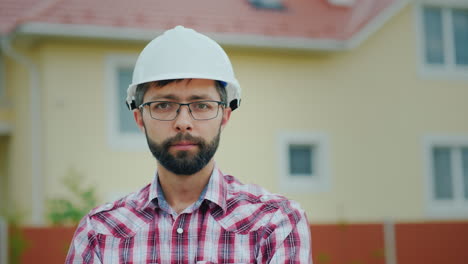 Portrait-Of-An-Attractive-Engineer-In-A-White-Helmet-It-Looks-At-The-Camera-Against-The-Backdrop-Of-