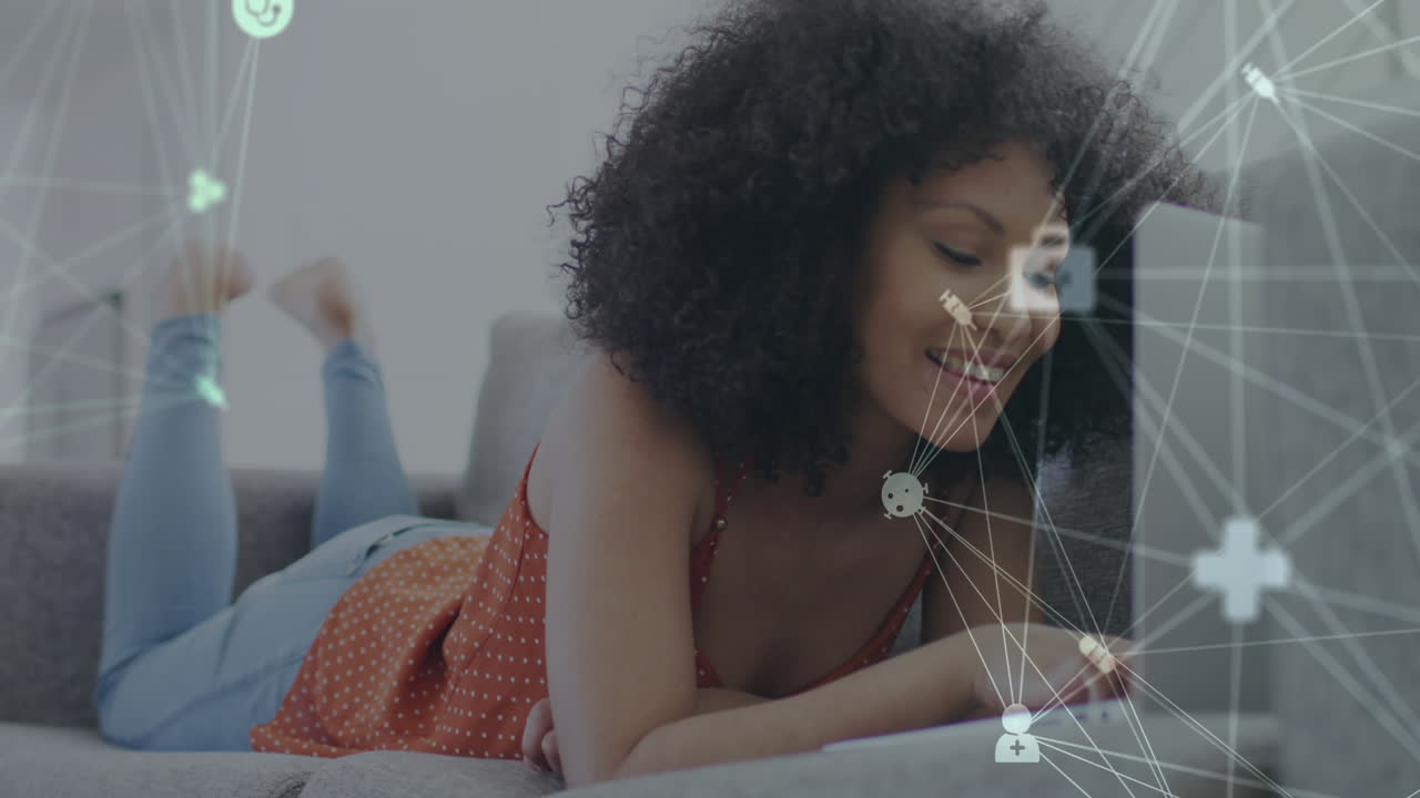 Animation of network of connections over smiling woman using laptop