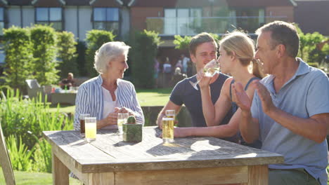 multi generation family enjoying outdoor summer drink at pub