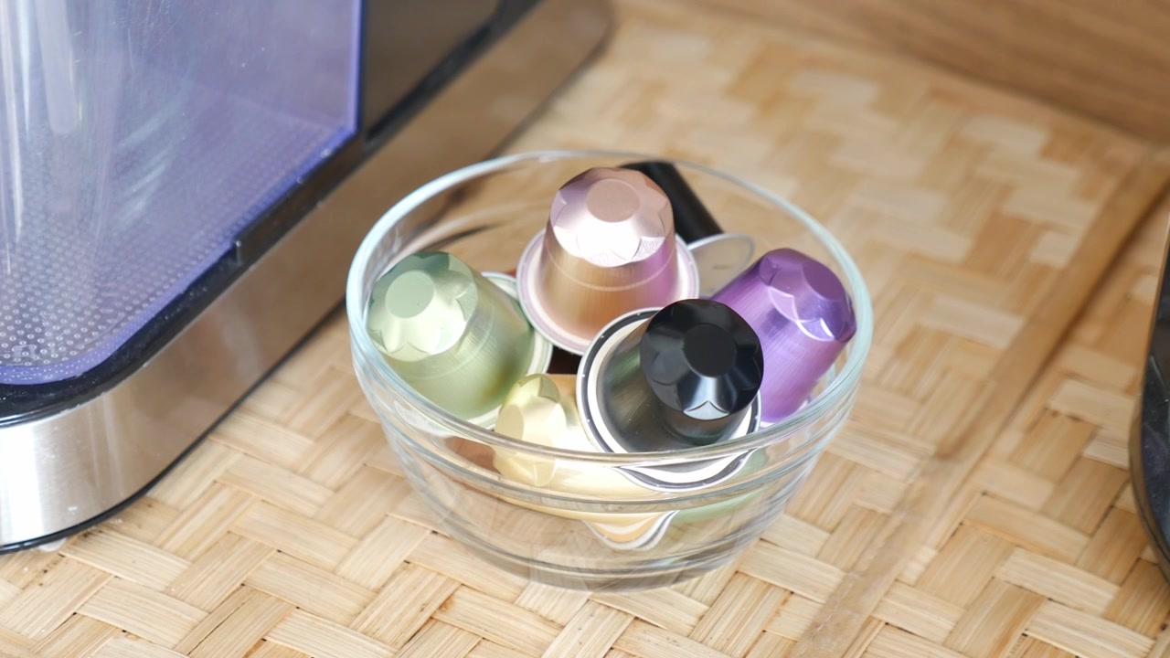 Colorful Coffee Capsules in a Glass Bowl Next to a Coffee Machine