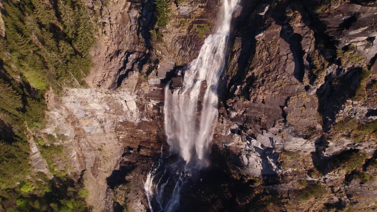 imágenes aéreas de drones orbitando en el sentido de las agujas del reloj vistas de arriba hacia abajo de una cascada de ensueño en grindelwald en los alpes suizos