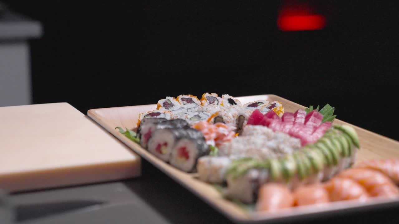 A slow roaming shot showcases a decorative plate filled with a variety of sushi rolls, highlighting vibrant colors and intricate presentation. Perfect for culinary, sushi, and food content.