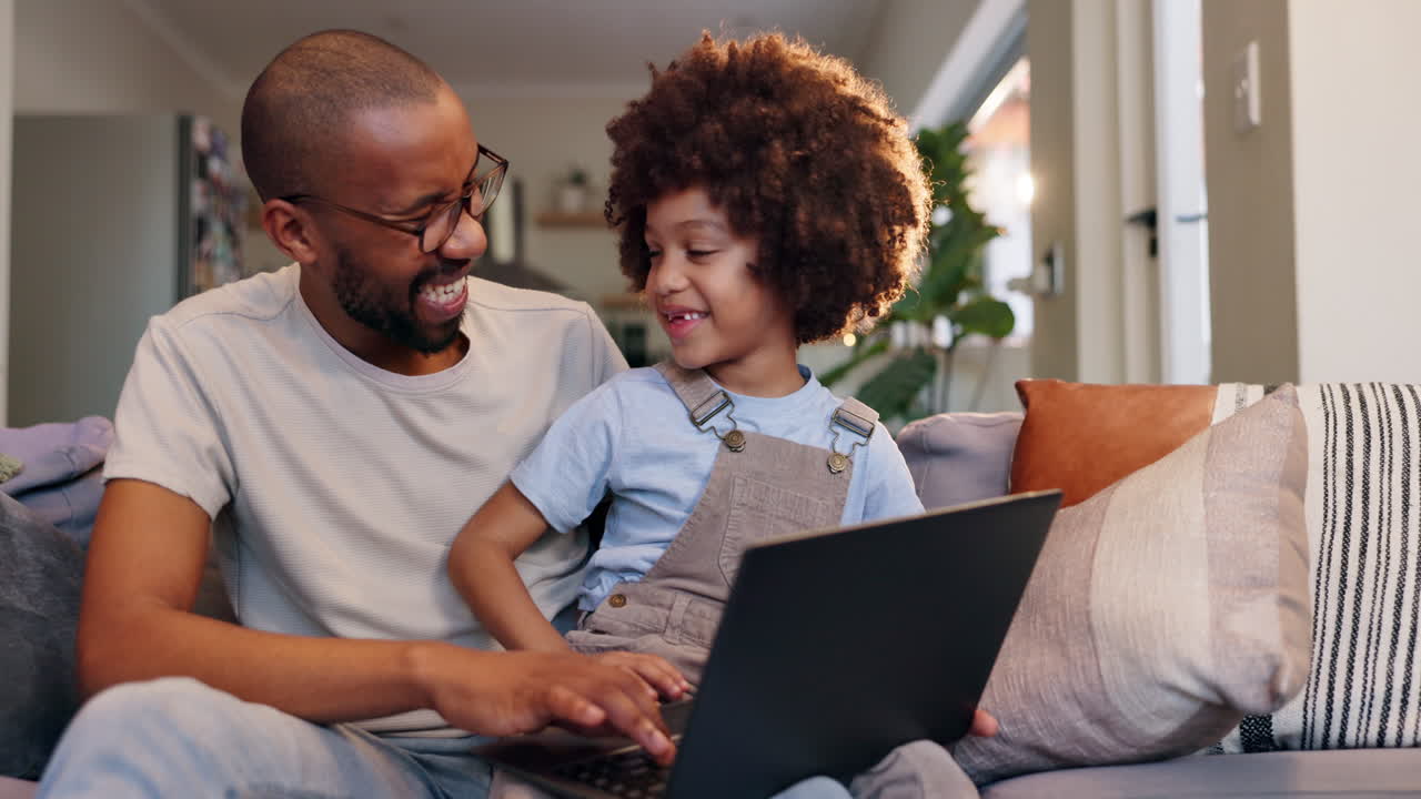 Father and son using laptop at home