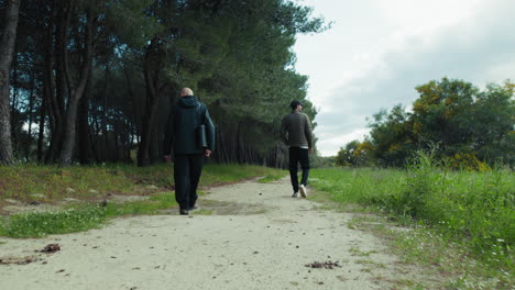 elderly father walks with son in cloudy days nature park