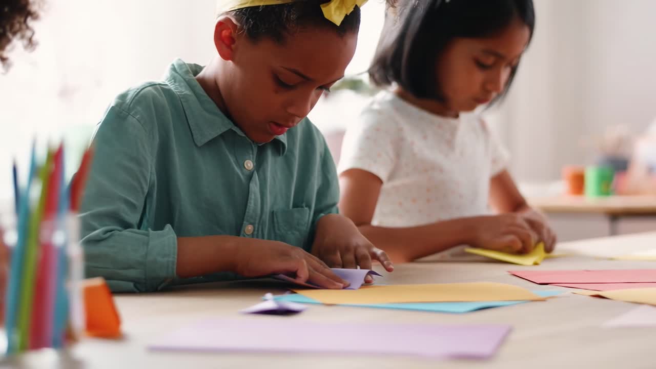 A close-up video captures children crafting with colorful paper, focused and creative