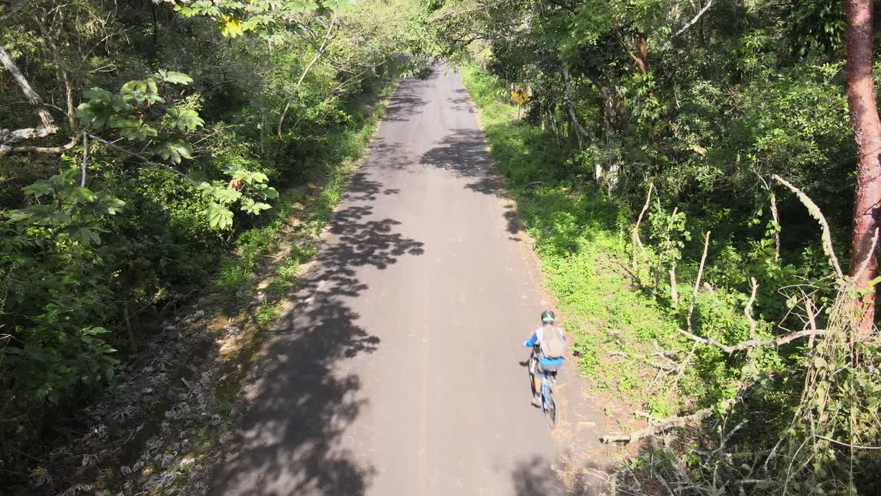 ciclista ciclista de montaña en las colinas de la carretera a la selva