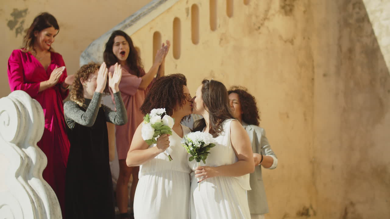 Happy brides descending stairs and kissing after wedding ceremony