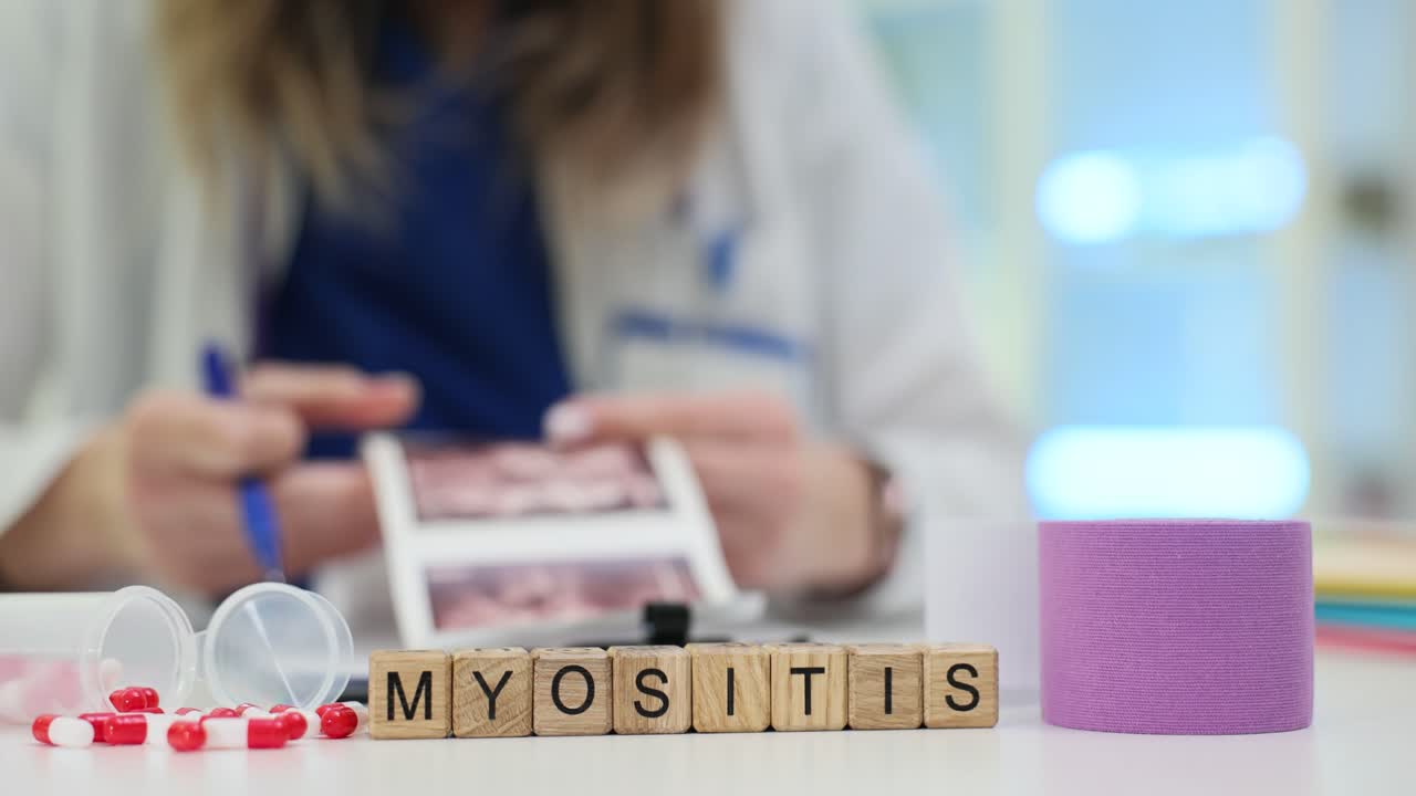 Cubi di legno formano la parola 'miosite' vicino a una benda medica e a scansioni.