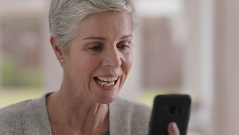 hermosa mujer madura teniendo video chat usando teléfono inteligente abuela disfrutando de la conversación mirando sorprendido compartiendo estilo de vida charlando en teléfono móvil relajándose en casa 4k