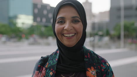 portrait of mature muslim woman laughing cheerful looking at camera happy enjoying urban city lifestyle wearing traditional hajib headscarf