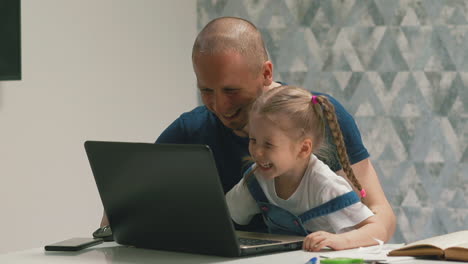 Papá-Feliz-Y-Su-Hija-Se-Divierten-Haciendo-La-Tarea-En-La-Computadora-Portátil