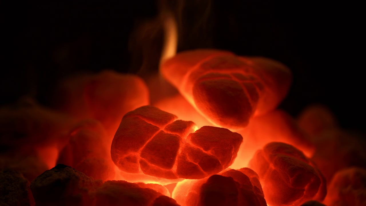 Bricchette di carbone impilate brillano con intense braci rosso-arancio, leggero fumo che sale, texture porosa e screpolata e ombra profonda su sfondo scuro, creando un calore drammatico e un contrasto atmosferico