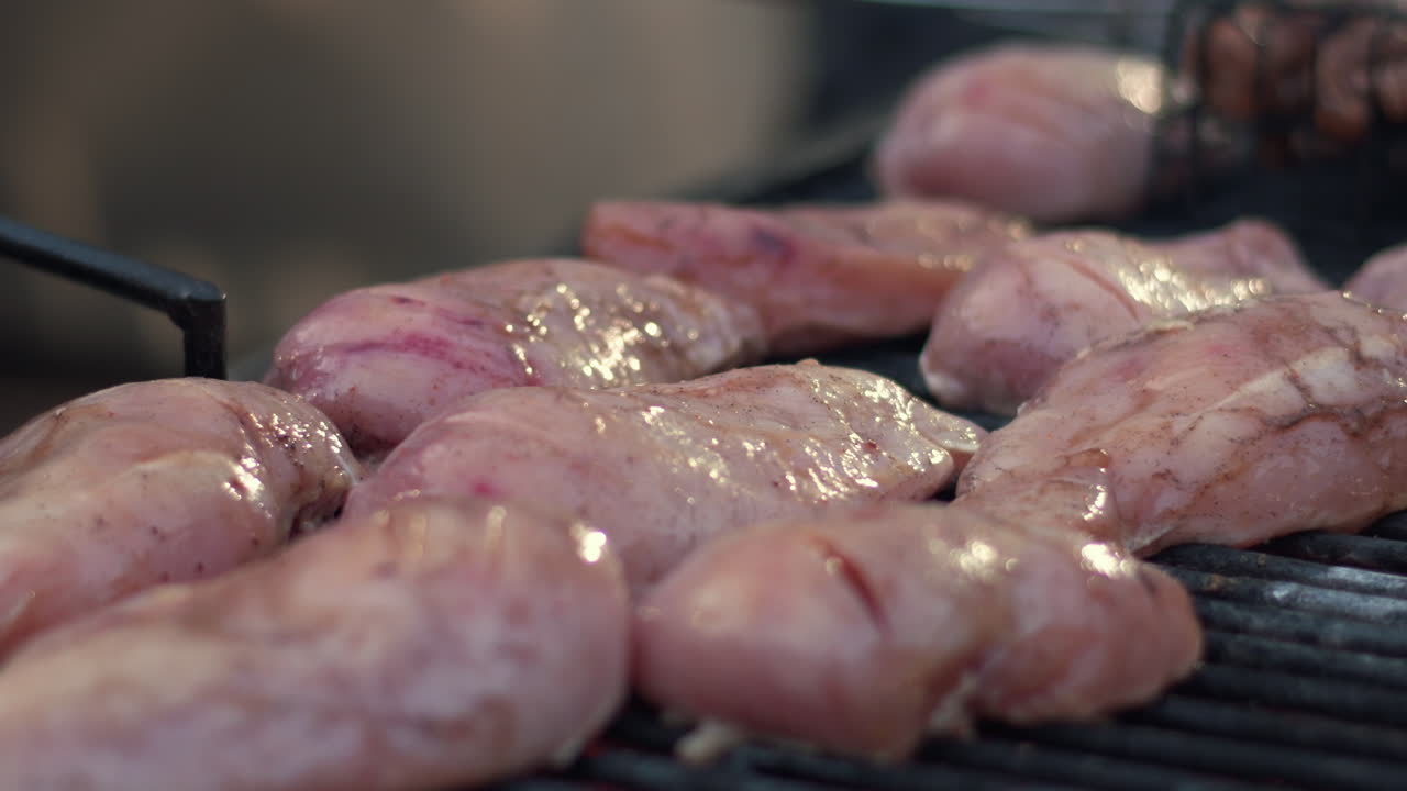 Closeup raw chicken breast preparing on grill outdoor.