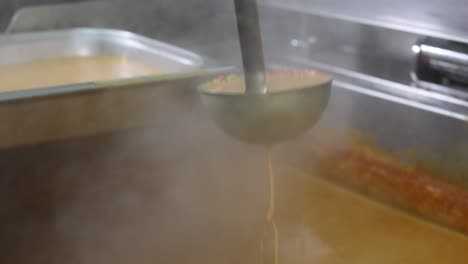 chef mixing curry sauce, close up on a hand, 4k footage