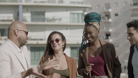 happy employees talking during rooftop party on summer day