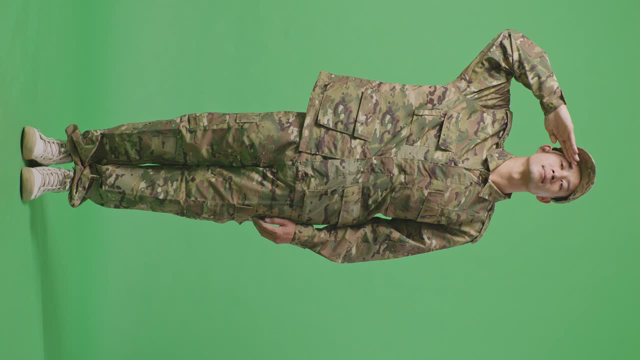 Full Body Of Asian Man Soldier Saluting While Standing In The Green Screen Background Studio
