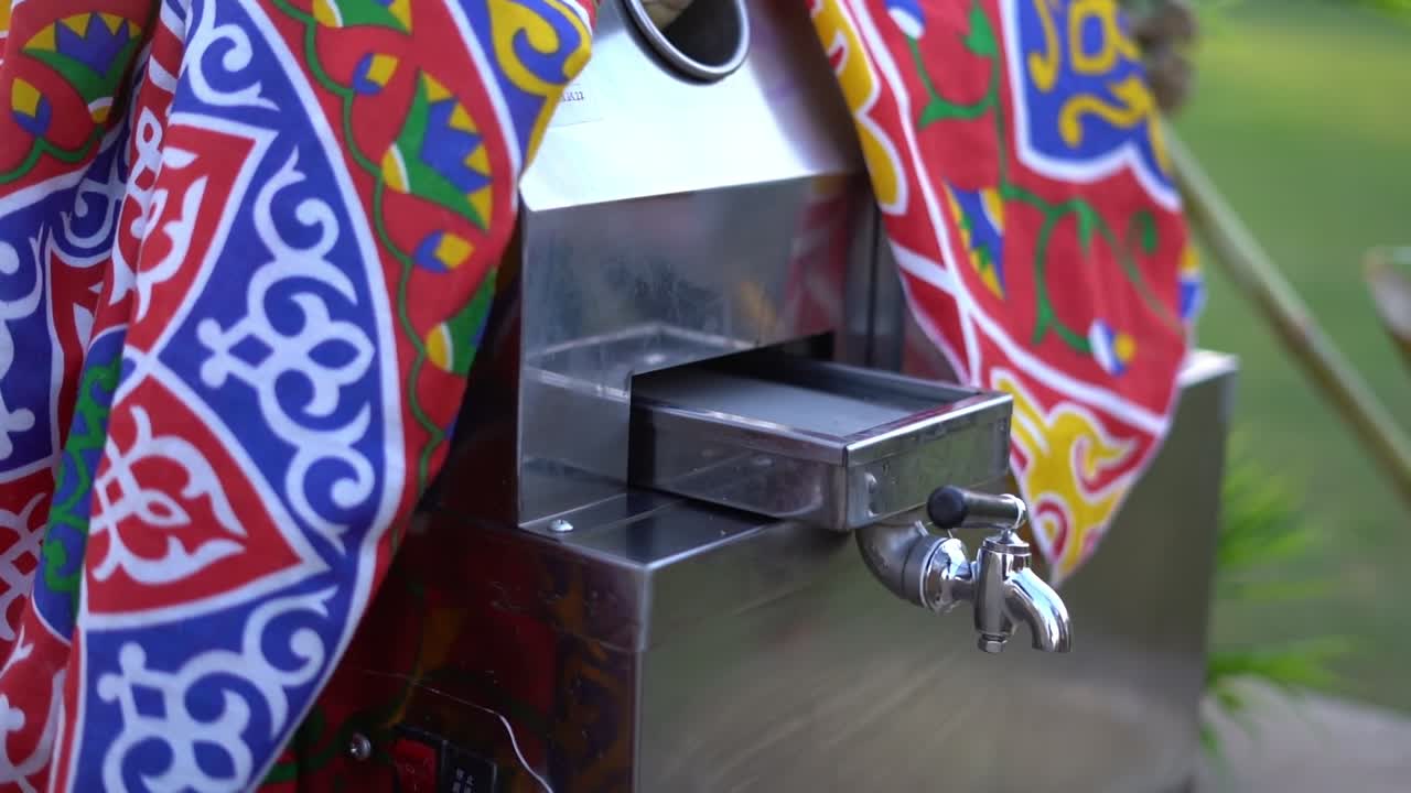 Fresh sugarcane juice being extracted using a traditional pressing machine, close up shot, insert shot