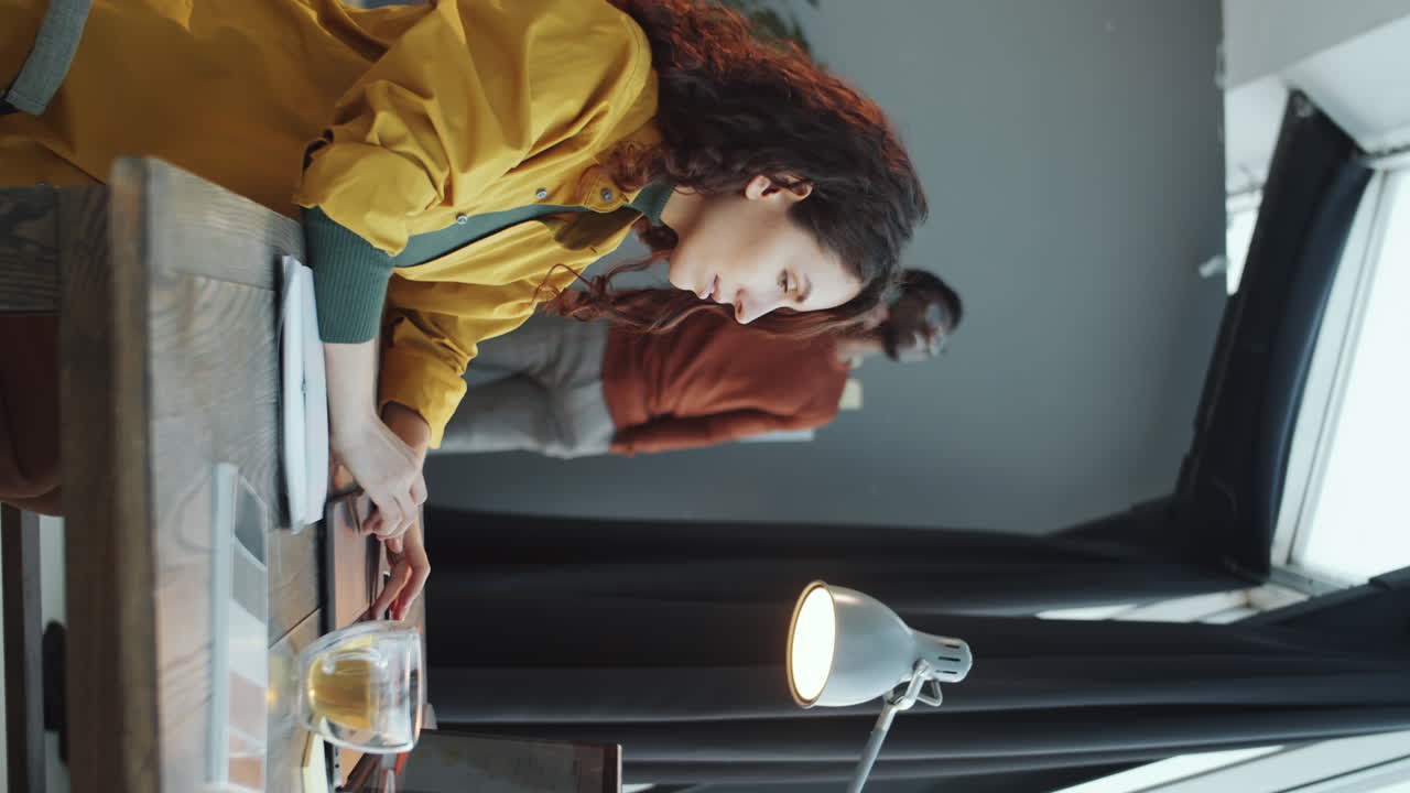 mujer usando una computadora portátil y tomando notas durante el día de trabajo en la oficina
