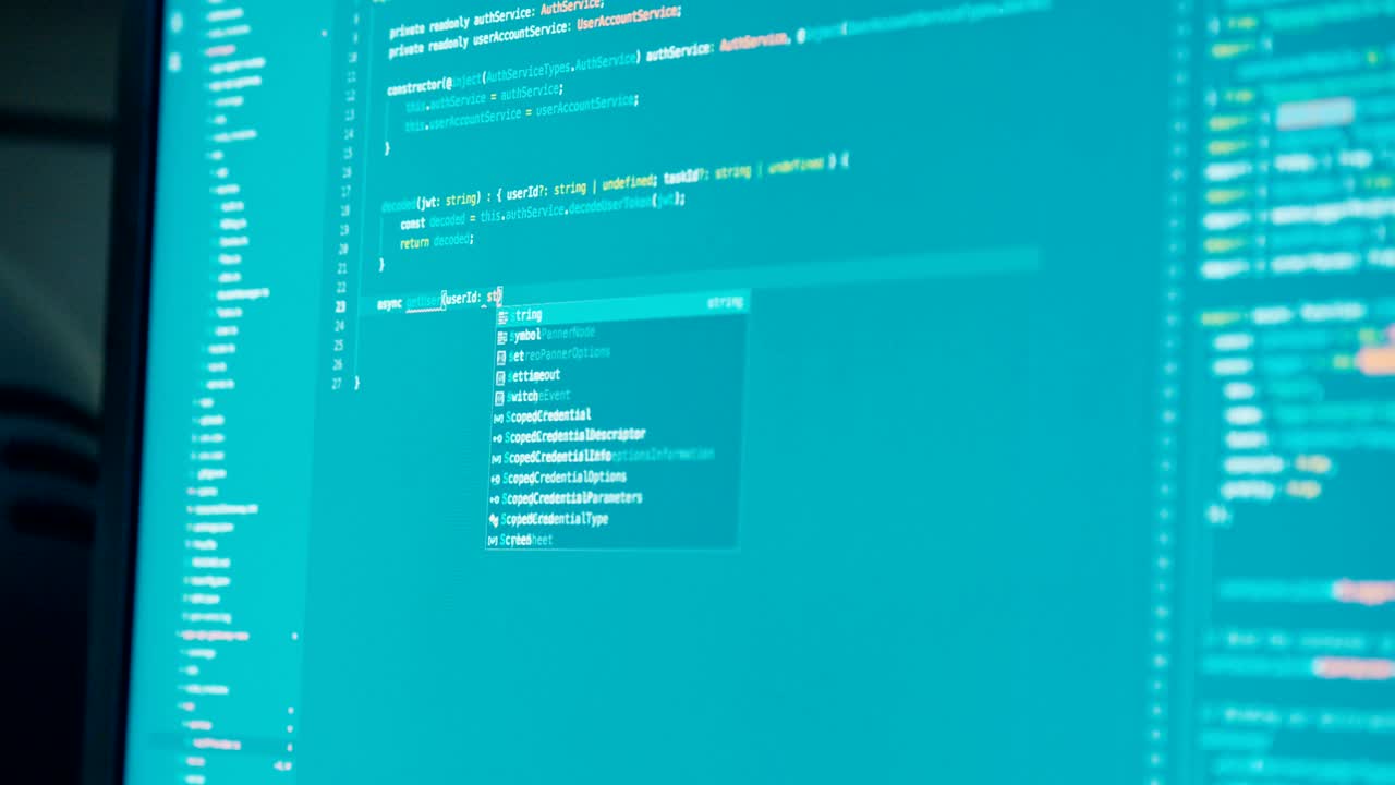 programador de computadora sentado frente a una pantalla codificando software