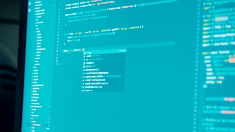 computer programmer sitting in front of a screen coding software