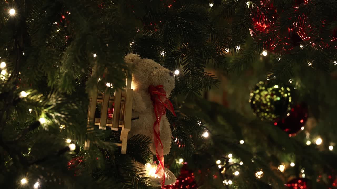 Teddy bear ornament on a Christmas tree, holiday background