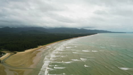 Wild-beach-of-Thailand-with-ocean-waves-roll-towards,-aerial-drone-view