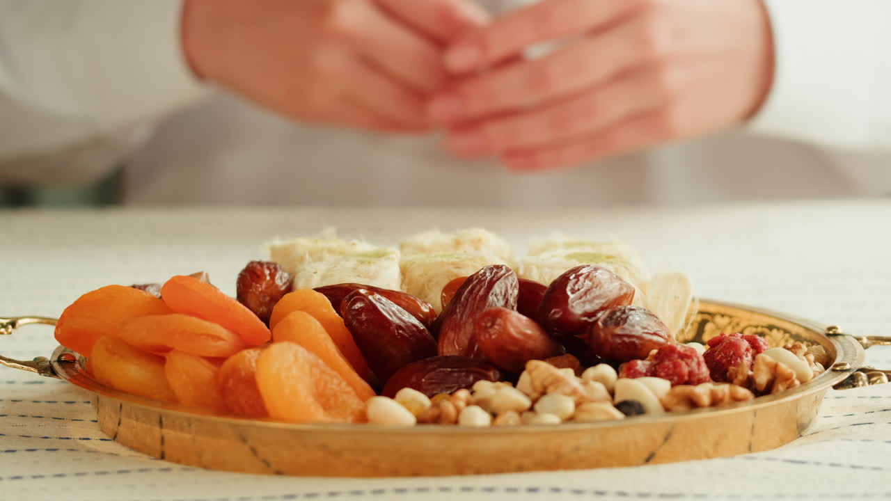 Hands holding a tray of dried fruit and nuts