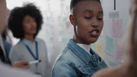 african american business woman using sticky notes brainstorming with colleagues in meeting team leader sharing creative problem solving ideas for solution enjoying teamwork in startup office