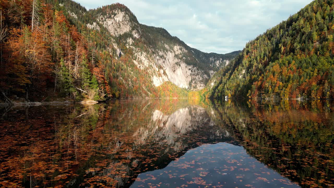 Lago calmo e limpido circondato da montagne verdi e lussureggianti