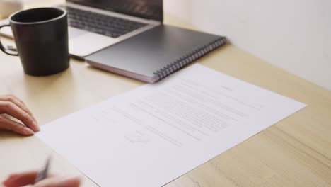 hand of businesswoman signing the document with pen in work office