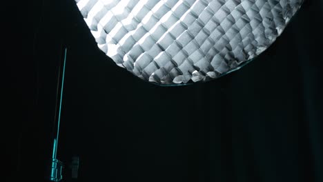 luz de estudio en un entorno de estudio oscuro con un trípode
