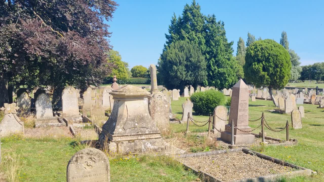 View across weathered tombstones in Crowland Abbey’s historic churchyard, Lincolnshire, captured on a bright summer’s day