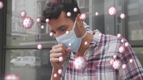 animation of covid 19 cells over caucasian man wearing face mask coughing