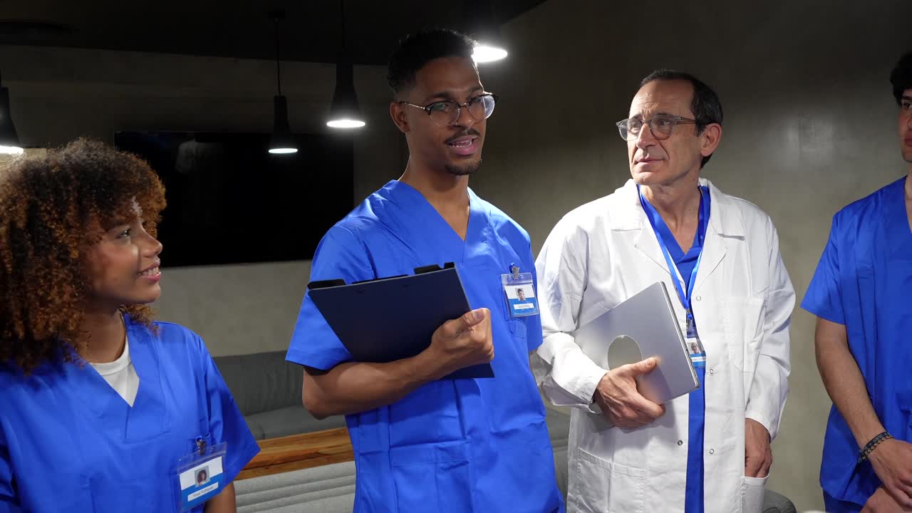 Gruppo eterogeneo di professionisti medici che applaudono e discutono
