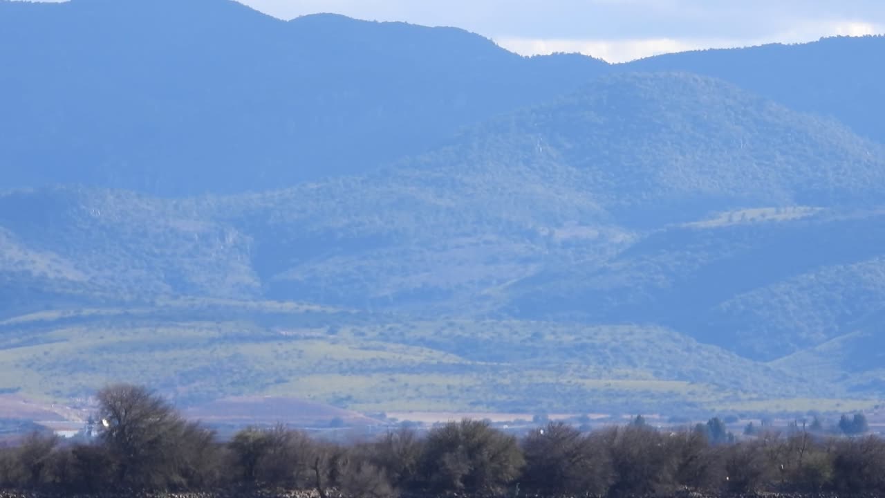 Stunning stock footage: Witness the dynamic dance of shadows on a lush green mountain as fast-moving clouds sweep by