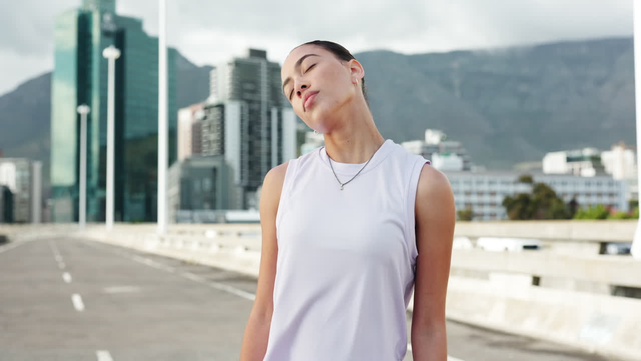 街の橋の上でストレッチやウォーミングアップをする若い女性。