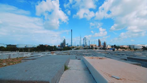 Lapso-De-Tiempo-Desde-Dentro-De-Un-Cementerio-Vacío-Con-Una-Gran-Refinería-Industrial-En-El-Fondo-En-Un-Día-Claro-Y-Soleado-En-Curacao