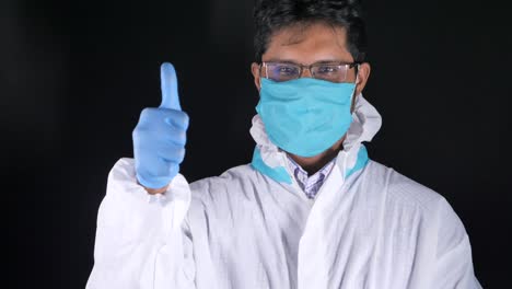 médico con equipo de protección dando un pulgar hacia arriba