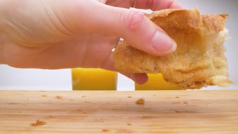 Close-up-shot-of-couple-splitting-croissant-into-two-pieces