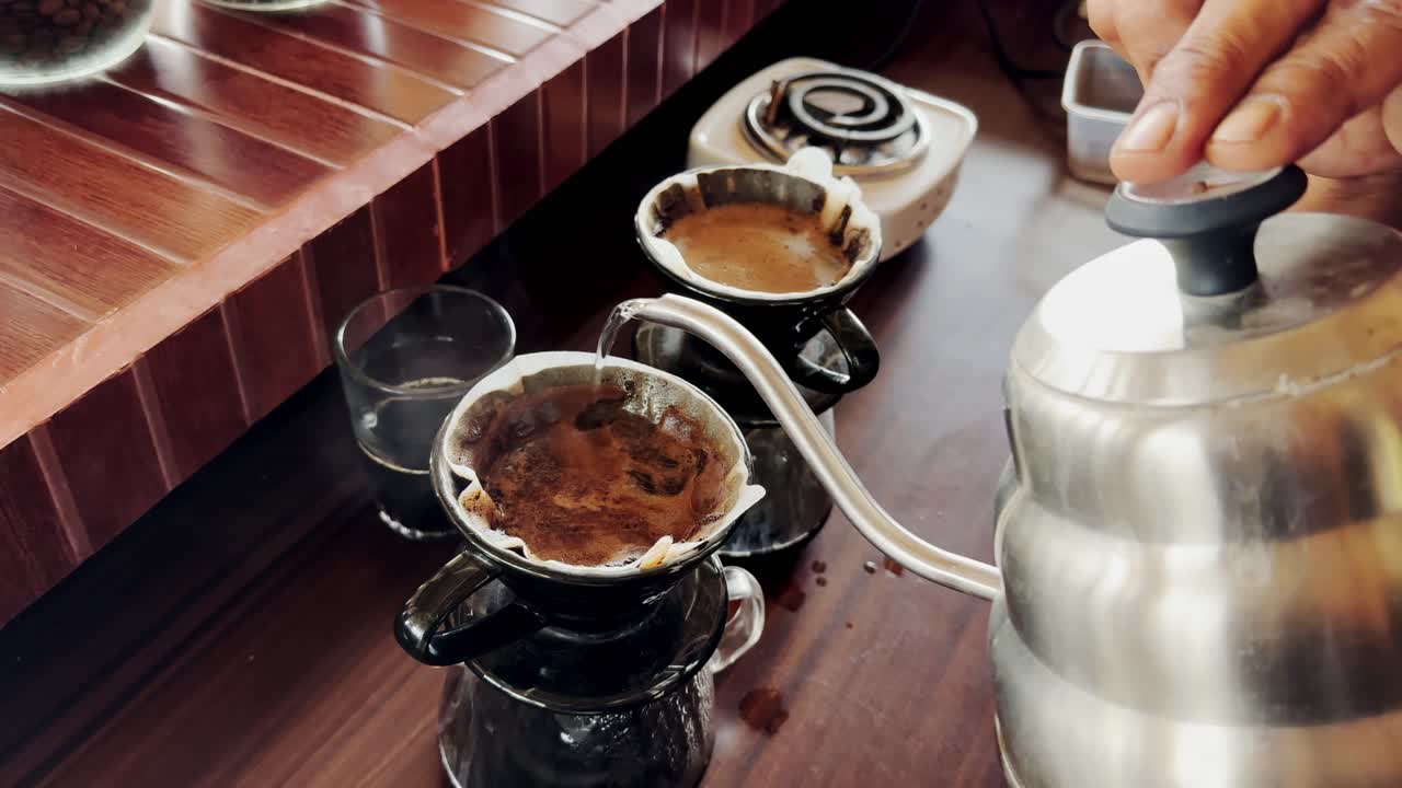 바리스타의 손은 커피와 함께 컵에 케이틀에서 뜨거운 물을 부어