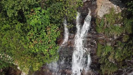 toma aérea ascendente mirando hacia abajo en una cascada y pasos de senderos para caminar