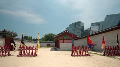 Valla-Protectora-De-Madera-De-Estilo-Antiguo-Del-Palacio-Gyeongbokgung-Contra-Guerreros-Que-Montan-A-Caballo-Con-Banderas-Coreanas-Históricas-Utilizadas-Durante-La-Recreación-Del-Cambio-De-Guardia,-Sin-Gente