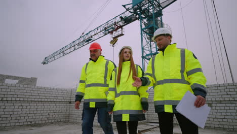 equipo de inspección de construcción está caminando en el sitio de construcción mujer ingeniero civil hombre capataz