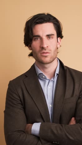 Disagreeing adult businessman shaking head in brown studio