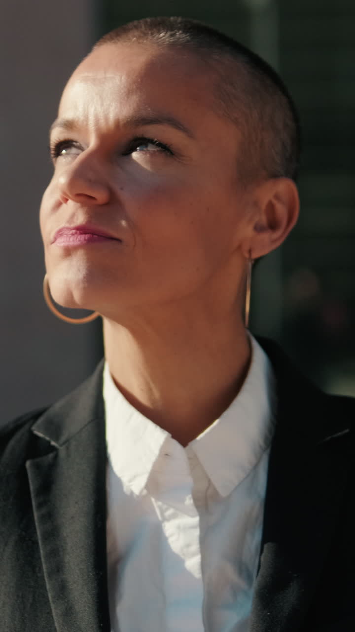 Mulher careca confiante olhando para cima sob o sol brilhante
