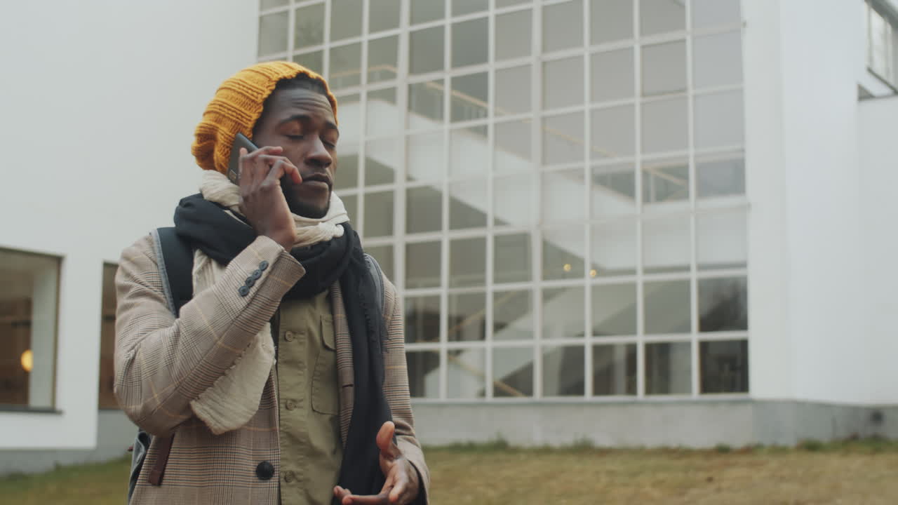 Uomo afroamericano che parla al cellulare all'aperto