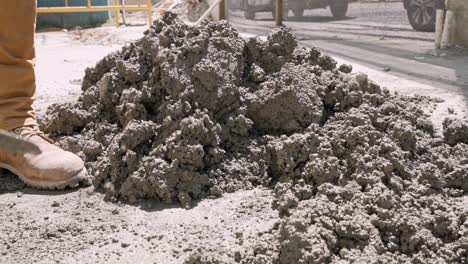 close-up shot of worker mixing cement with a spade manually