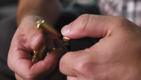 man unloading bullets from a pistol magazine