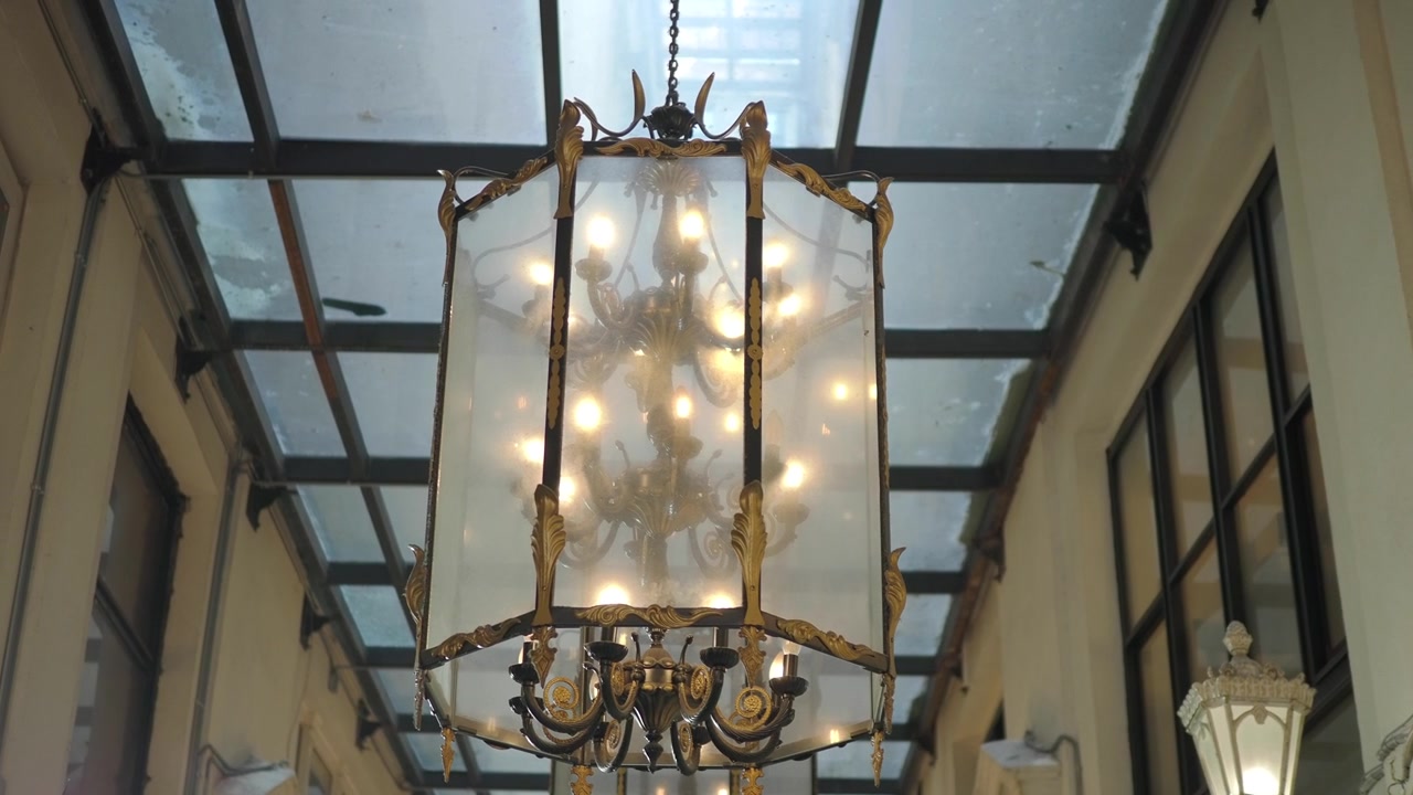 Lampadario vintage ornato appeso in un corridoio con tetto in vetro
